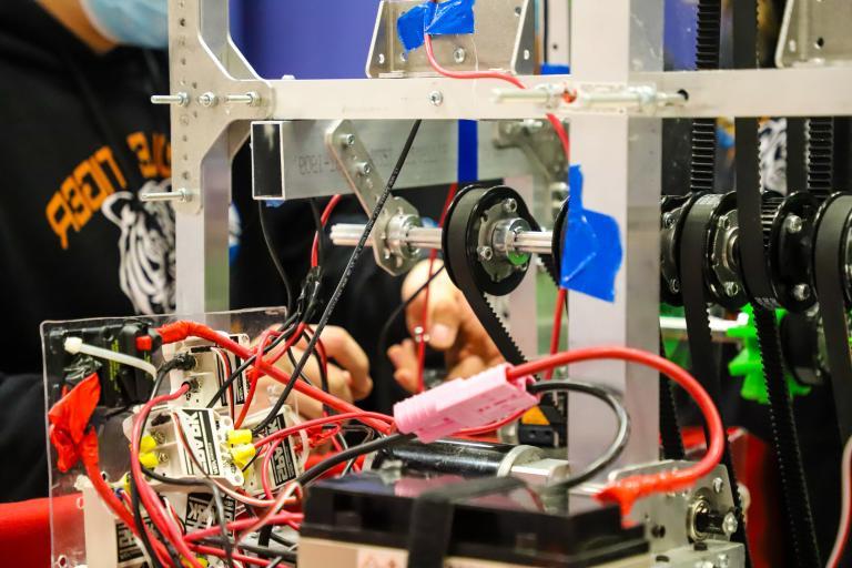 A student works on his robot's wiring at 正规的赌博app.